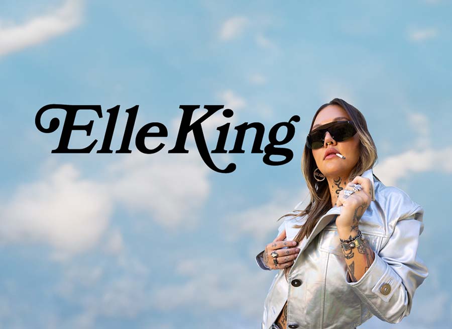 "Elle King" picture of Elle King posing with clouds and blue sky as back drop.